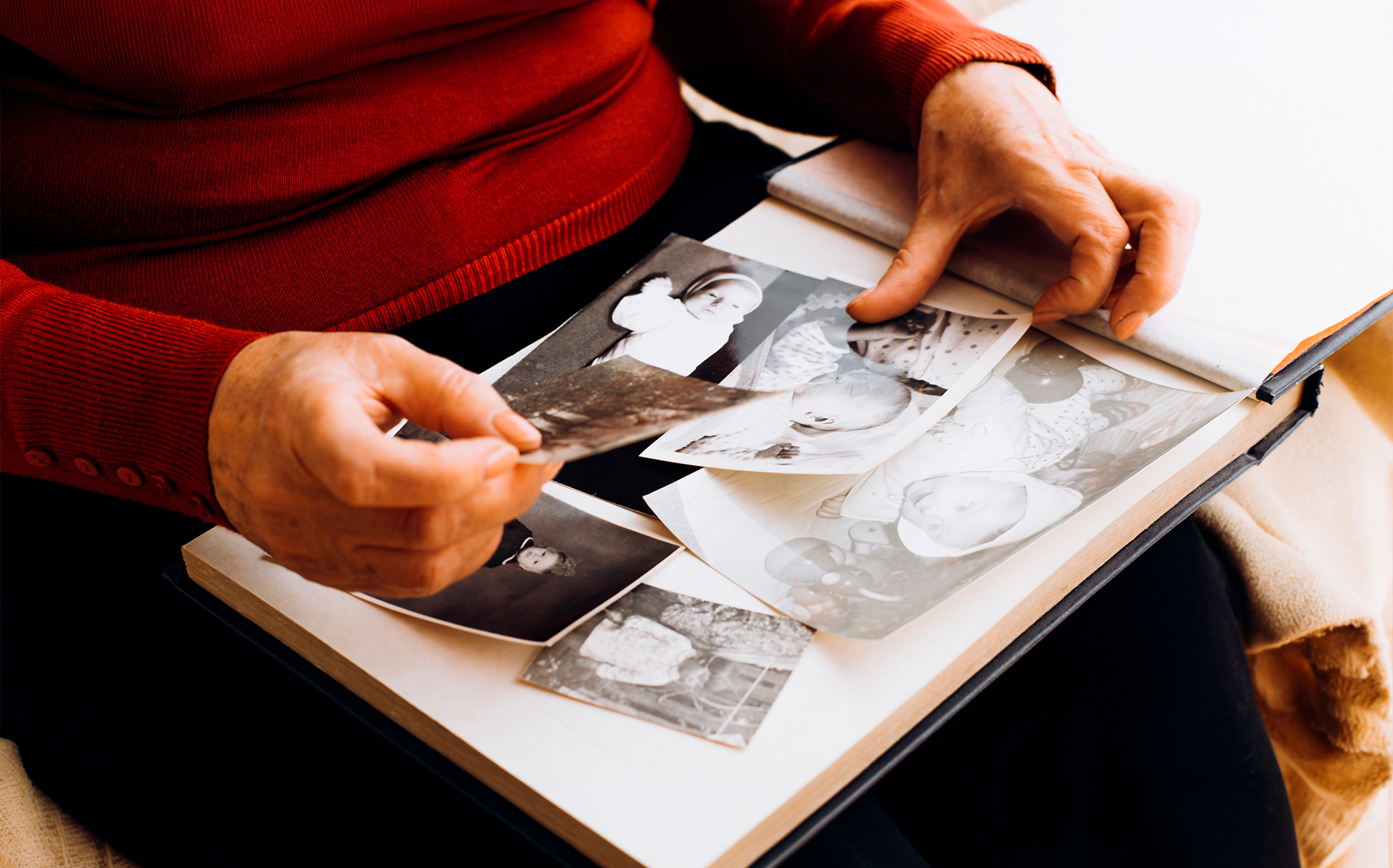 Persona contemplando fotos familiares. © Shutterstock. Sergio Photone